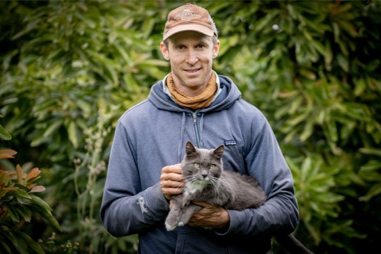 man with blue sweatshirt holding cat